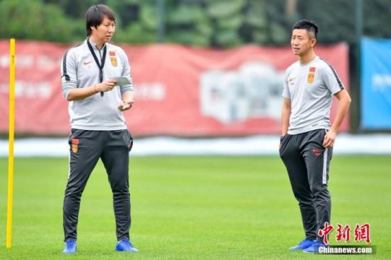 中国国家男子足球队主教练李铁(左)在训练场上规划训练。中新社记者 陈骥�F 摄