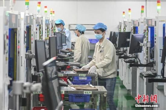 资料图：2月20日，位于广州南沙区的安捷利(番禺)电子实业有限公司内，复工人员戴着口罩在生产车间有序工作。中新社记者 陈骥旻 摄