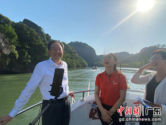 直播当日天朗气清，市长殷焕明（左）与当地导游正在拼多多直播间为全国网友介绍水上丹霞。
