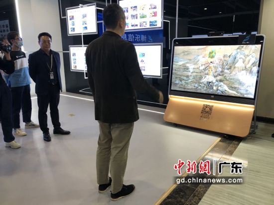 图为深圳市博乐信息技术有限公司负责人在一体机前进行互动体验展示。 朱族英 摄 