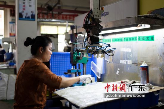 深圳市迪菲帆科技有限公司工作人员在检查机器生产的手机壳。陈楚红 摄 