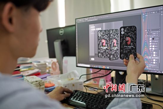 深圳市联合通科技有限公司的工作人员将手机壳产品与淘宝页面展示图作比对。陈楚红 摄 