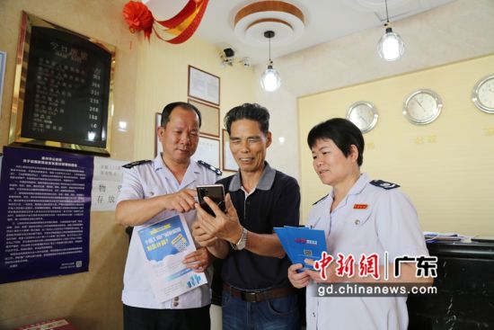 图为惠东县税务局工作人员在帮助老年纳税人迈过“数字鸿沟”关。 冯素文摄