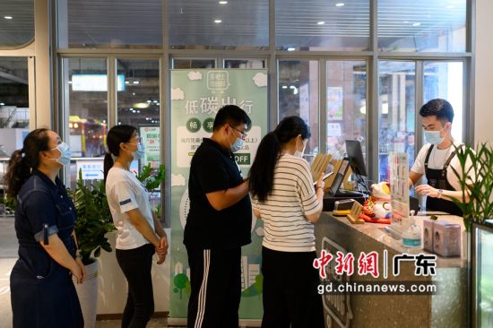 市民在广州火车东站公交站场的“茶吧士”茶饮店排队购买饮品，享受优惠。陈楚红 摄 