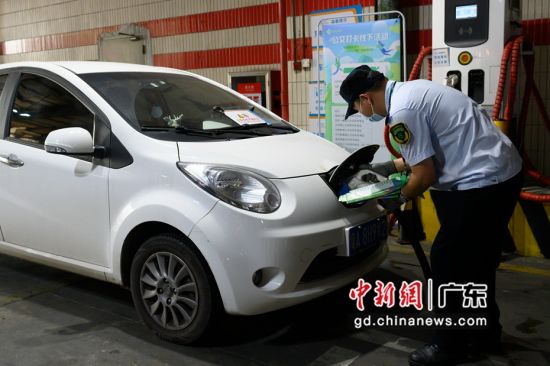 广州火车东站公交站场充电站工作人员给新能源汽车充电。 陈楚红 摄