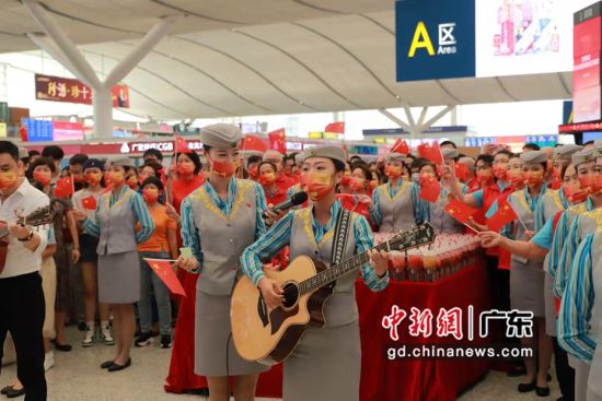 深圳北站10名靓丽的乘务员，手举小国旗，正深情地演唱《我和我的祖国》 作者 胡福祥