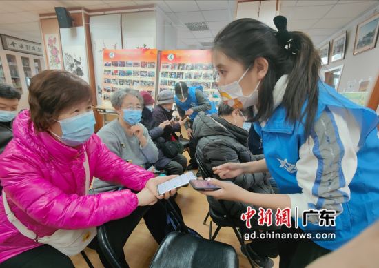 虎牙志愿者向老年人示范操作智能手机，受访者供图。