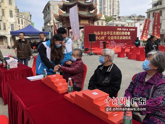 活动现场“侨心桥”项目人员为老人们调试设备 作者 李怡青