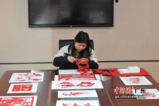 1月26日，广东省潮州市，吴岱敏在广州动车段潮州动车制作冬奥主题剪纸作品。陈楚红 摄