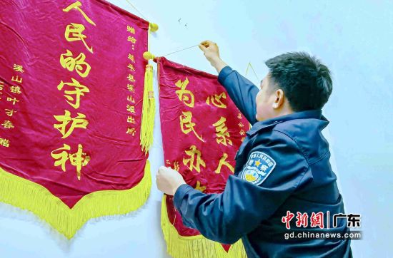 图为广东连平县公安民警欧伟锋整理悬挂百姓赠予的锦旗。 作者 颜新阳摄