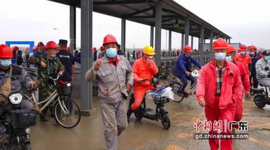 3月25日疫情管控恢复常态化当天，施工人员通过门闸进入现场，全项目返场22257人。刘嘉亮摄