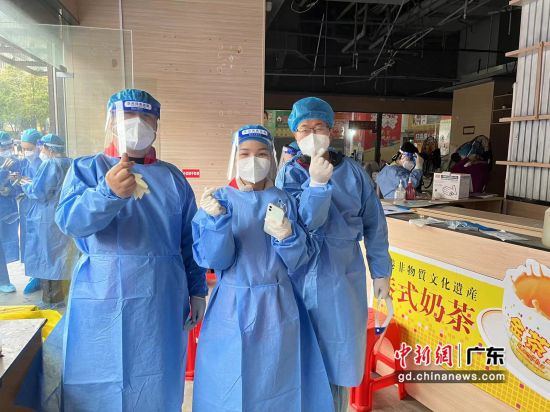 志愿者在白云区核酸检测开始前比心合影 作者 陈鑫昊