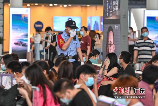 广铁警方在广州南站候车大厅内指引旅客佩戴口罩。 作者 陈骥�F