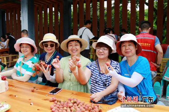 图为组团前往荔枝公园的姐姐们开心的品尝荔枝。 作者 吴凌飞 摄