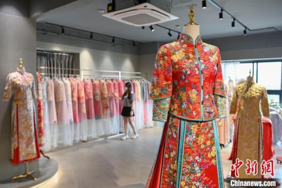 黄美招在佛山创办了皇潮褂绣庄，各式各样的中式嫁衣供消费者选择。　陈骥�F 摄