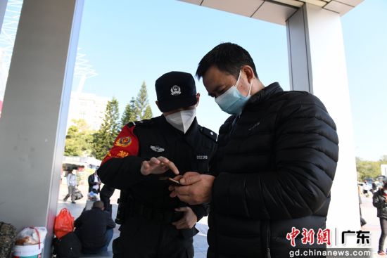 图为惠州铁路公安处值勤民警引导旅客扫码。 作者 张科军 摄