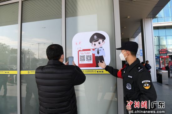 图为惠州铁路公安处值勤民警在惠州站进站口引导旅客扫码。 作者 张科军 摄