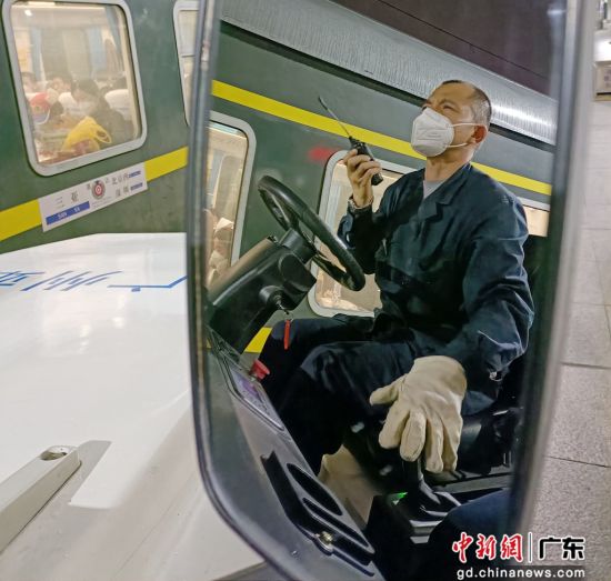 许新奇驾驶着一辆白色牵引机车分批次将一辆辆满载货物的板车拉上站台 作者 黎熙齐