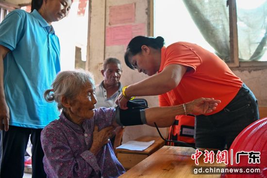 护理员为老人检测血压。记者 陈骥�F 摄