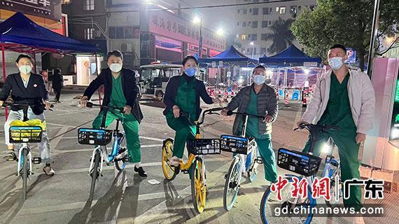 完成核酸采样任务后，已是夜里8、9点。黄炜（左二）与同事们骑共享单车返回医院。