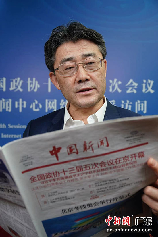 全国两会期间，全国政协委员高福在委员驻地阅读中国新闻报。